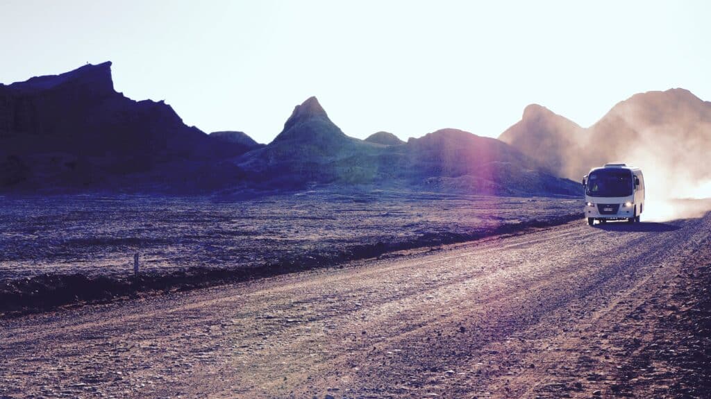 A white van driving along an empty road in the Atacama desert in Chile