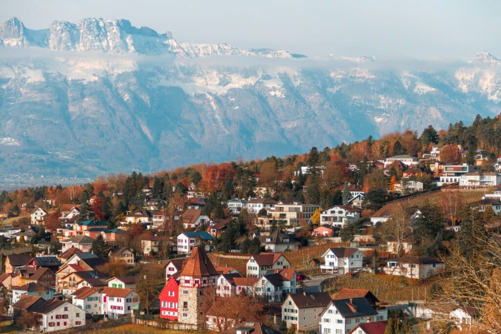 The photo shows the city of Vaduz, capital of Lichtenstein, and its snow-capped mountains.