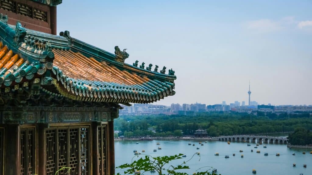 Foreground view of the roof of a Beijing temple, overlooking the city and its river in the background.