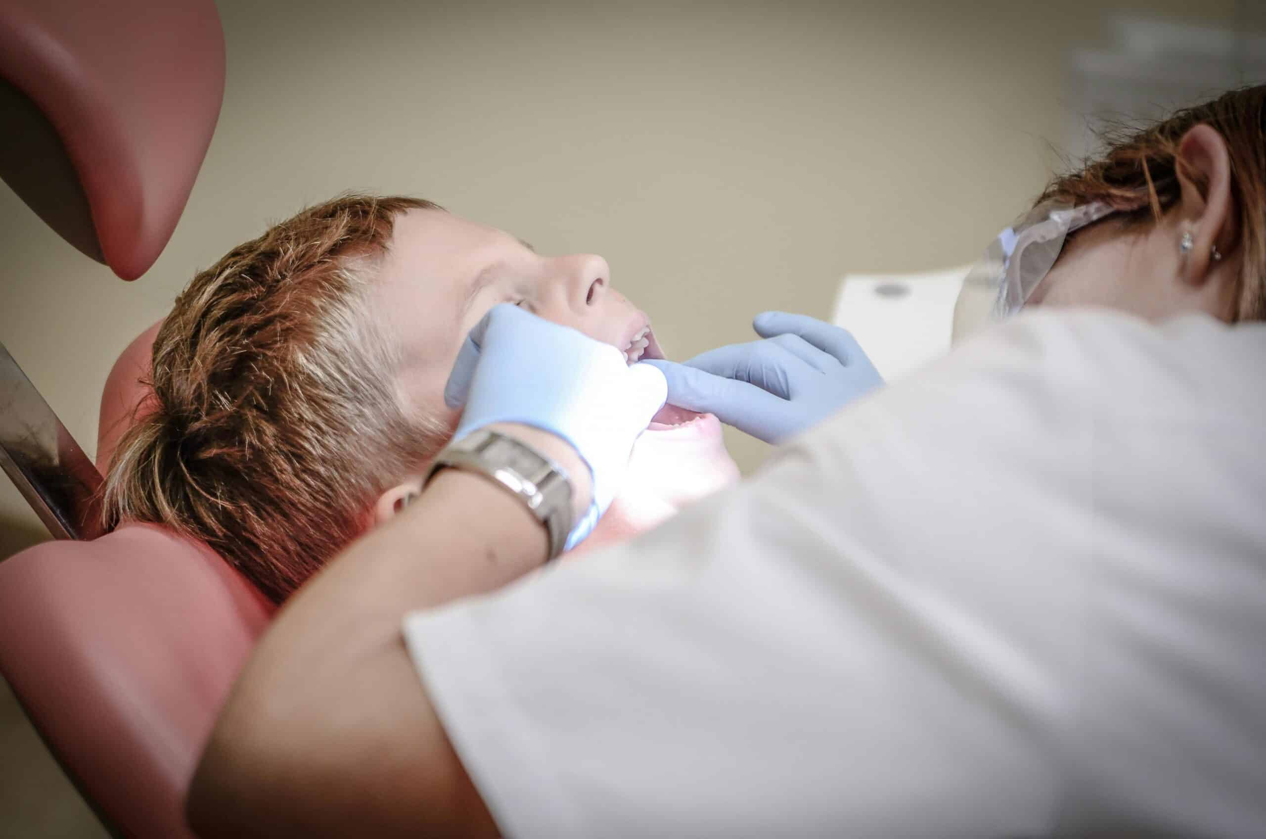 As a little boy at a dentist's appointment, he has his teeth fixed by a dentist.