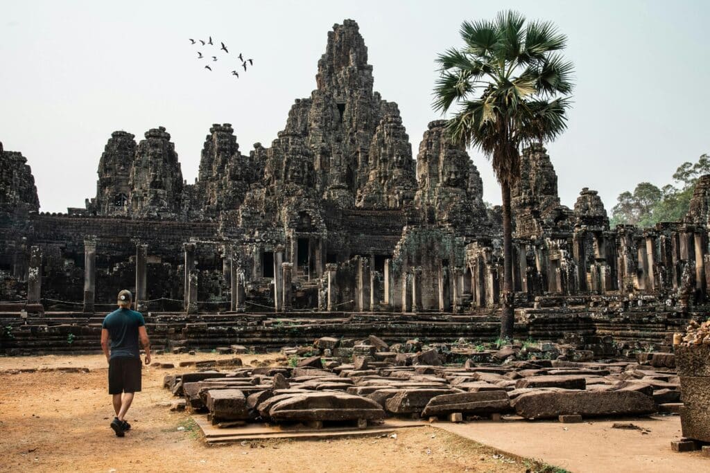 Man looking at and visiting the ancient temple of Angkor in Cambodia