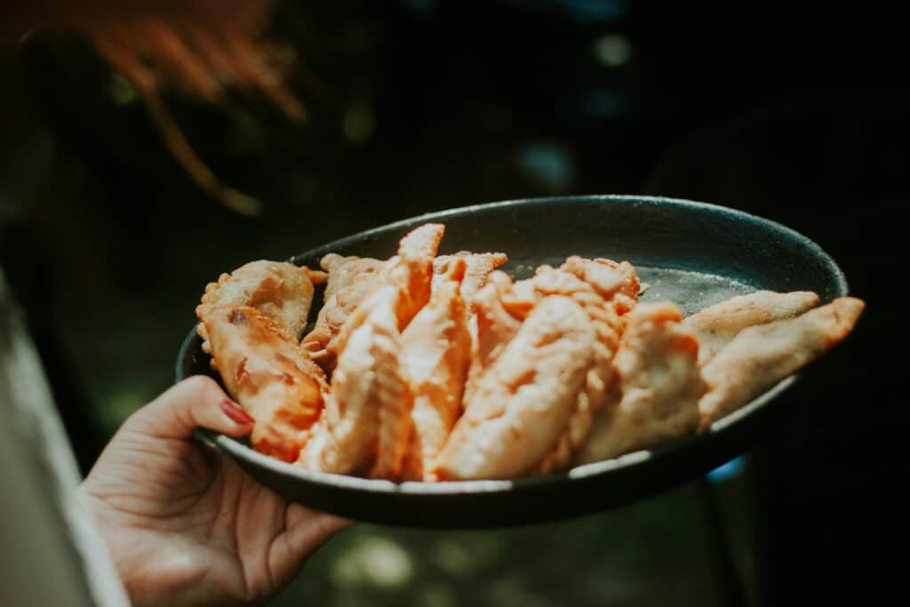 Person holding a plate of Argentinian empanadas.