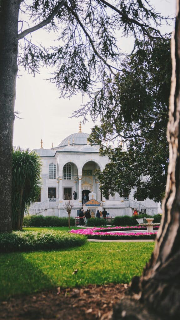 Entrance to the Topkapi Palace in Istanbul, Turkey, overlooking a garden planted with trees.