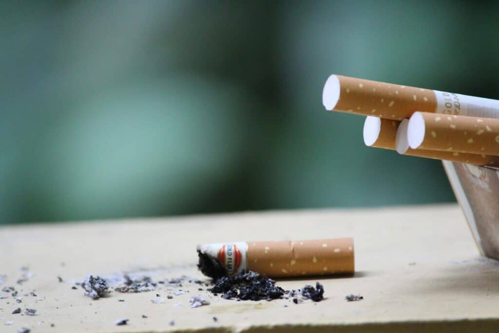 Close-up of smoked cigarettes on a wooden table.