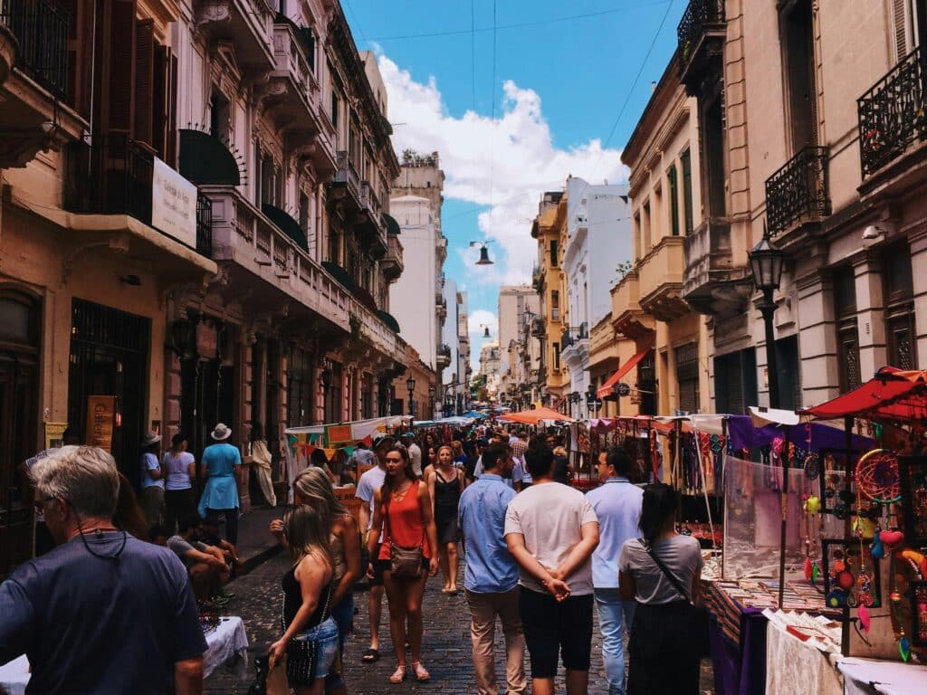 Crowd of people in the streets of San Nicolas, Argentina, on a market day under clear skies.