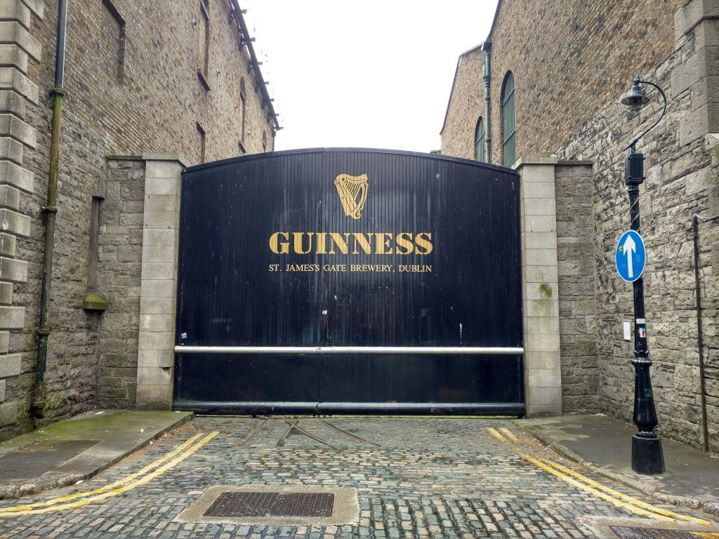 Façade of the entrance to the Guinness museum and factory in Dublin, Ireland. The black metal door with the logo and address of the site leads to a dead end.